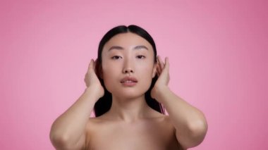 Sevgi ve ilgi. Ayna pov portresi. Genç, güzel Asyalı bir kadın. Saçını düzeltiyor, görünüşünden zevk alıyor.