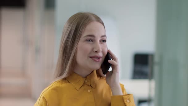 现代商务沟通。在办公室通过手机与伴侣交谈的积极的年轻女经理 — 图库视频影像