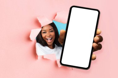 Siyah kadın yırtık kağıtlarla beyaz akıllı telefon ekranı gösteriyor