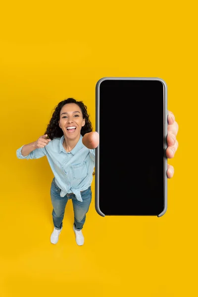 Happy lady showing blank mobile phone screen at studio — Foto Stock