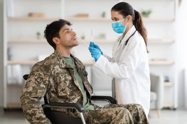 Ιατρός που λαμβάνει δείγμα για δοκιμή PCR από στρατιώτη με αναπηρία — Φωτογραφία Αρχείου