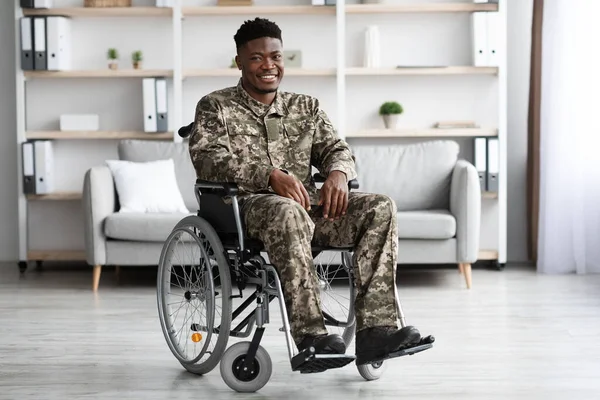 Boldog fekete katona ül tolószékben, klinika belső — Stock Fotó