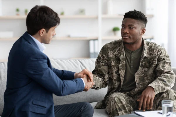 Mutlu siyah asker psikolog elini sıkıyor.