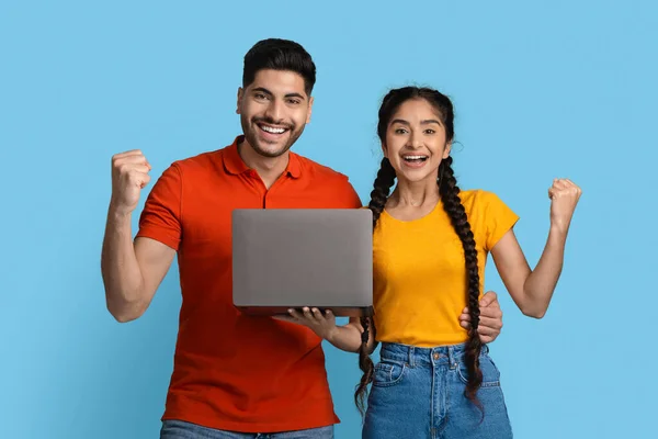 Online Win. Portrait Of Young Arab Couple Cheering Success With Laptop —  Fotos de Stock