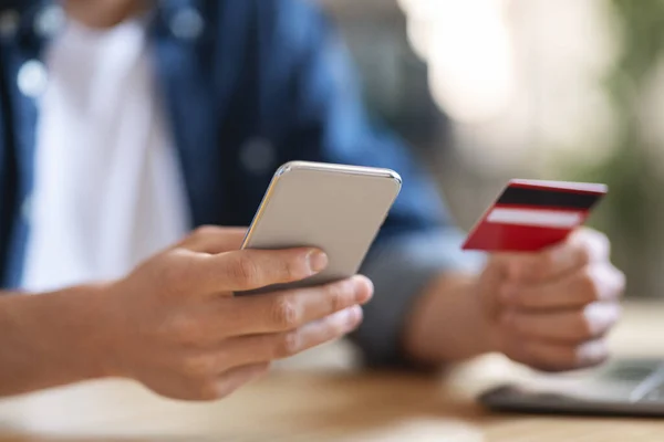 Online Payments. Closeup Shot Of Man Using Smartphone And Bank Card — стоковое фото