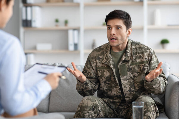Emotional soldier sharing his thoughts with woman psychotherapist