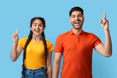 Neşeli genç Arap Çifti Fikir ve fikir sahibi, parmaklarını havaya kaldıran