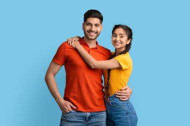 Kameraya sarılıp poz veren genç, pozitif Arap bir çift portresi.