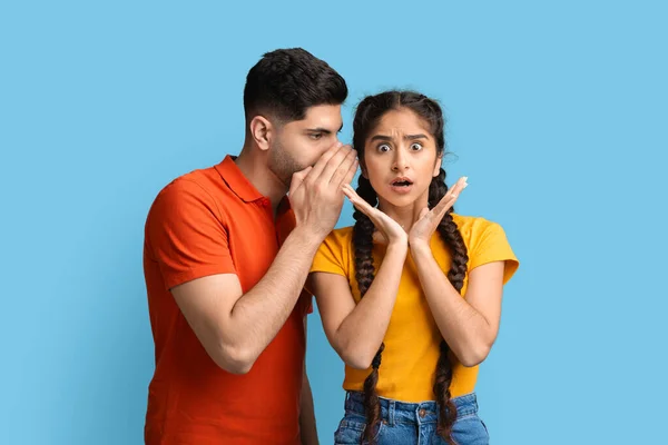 Homem árabe compartilhando informações com sua namorada preocupada, sussurrando ao ouvido — Fotografia de Stock