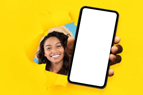 Black lady showing white empty smartphone screen through torn paper — Fotografia de Stock
