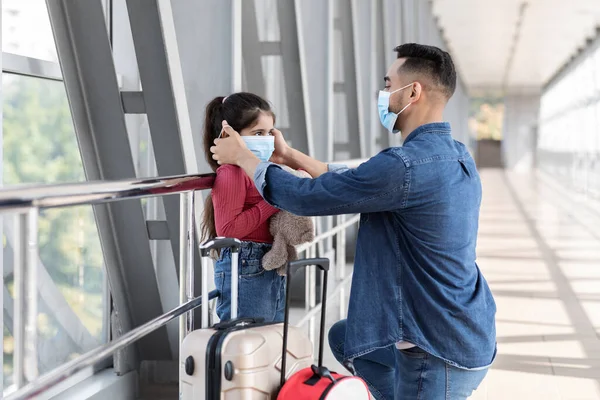 Caring Arab Father Wearing Protective Medical Mask To His Daughter At Airport —  Fotos de Stock