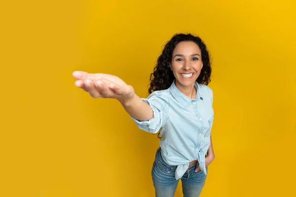 Smiling young woman outstretching hand, trying to hold something — Stockfoto