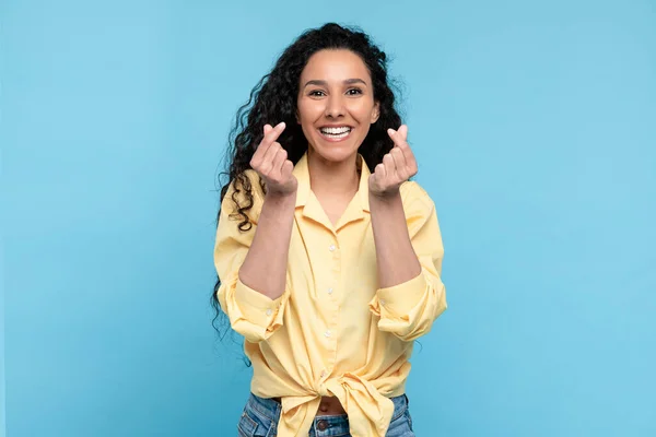 Smiling young woman making Korean finger mini heart gesture — Zdjęcie stockowe