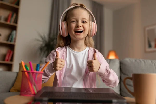 Joyful Schoolgirl Showing Like To Laptop Learning Online Sitting Indoors — Stockfoto