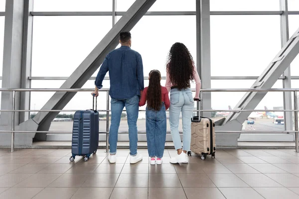 Air Journey. Family In Airport Holding Hands And Looking At Window — Foto Stock