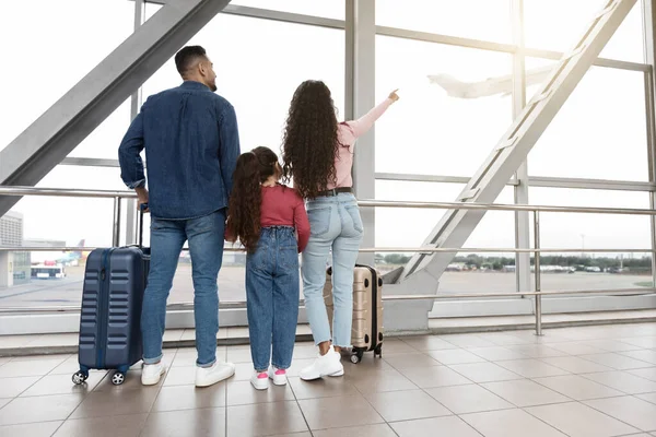 Family Of Three Looking Out Of Window At Airport And Pointing Away — Stockfoto