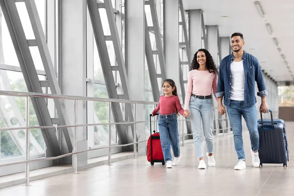 Anuncio de viajes. Retrato de familia árabe feliz caminando con equipaje en el aeropuerto — Foto de Stock