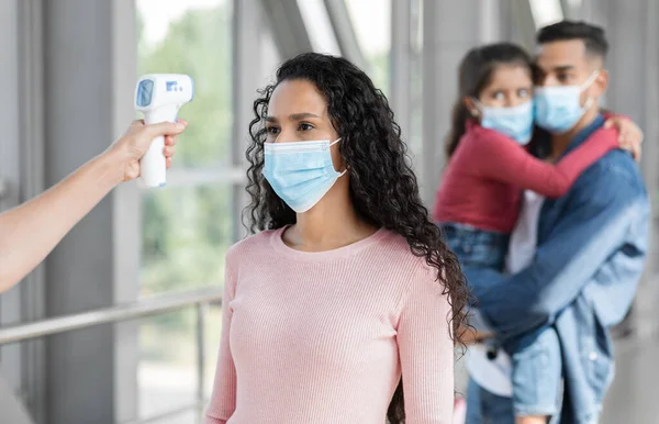 Travel Safety. Airport Stuff Checking Temperature Of Female Passenger In Medical Mask — 스톡 사진