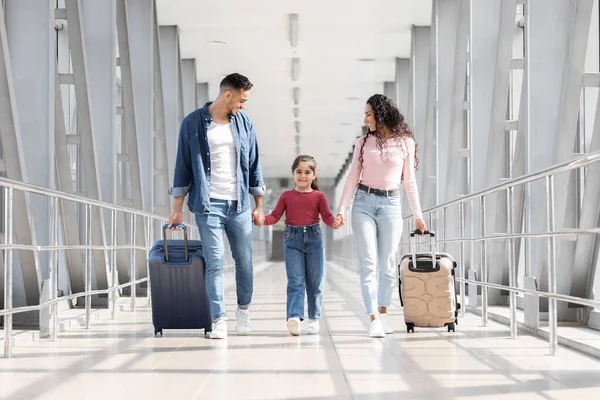 Viaggiare insieme. Gioiosa famiglia araba che cammina con valigie al terminal dell'aeroporto — Foto Stock