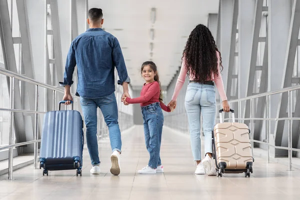 Cute little girl walking with parents together in airport terminal — Foto Stock