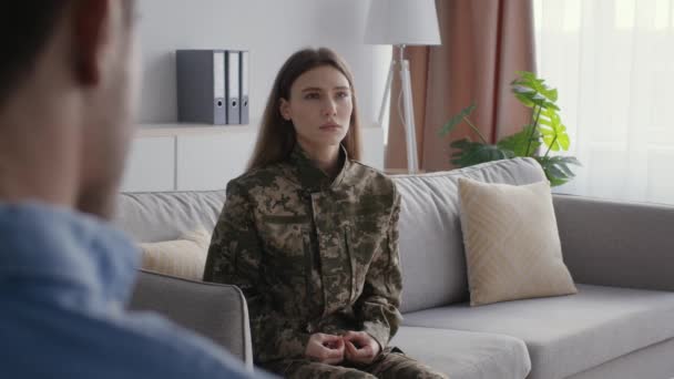 After war psychological recovery. Young depressed woman soldier in camouflage talking with man psychologist, free space — Stock video