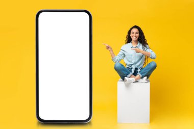 Woman pointing on big white empty smartphone screen