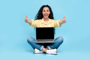 Mutlu kadın siyah boş dizüstü bilgisayar ekranı gösteriyor.