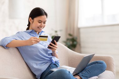 Mutlu Asyalı kadın serbest bankacılık online, akıllı telefon kullanıyor.