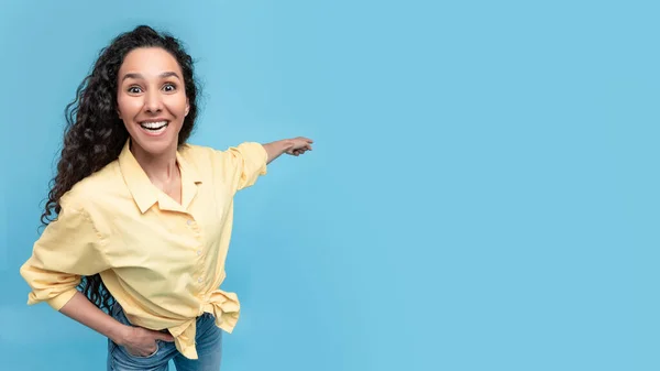 Excited woman pointing finger back at copy space — Stok fotoğraf