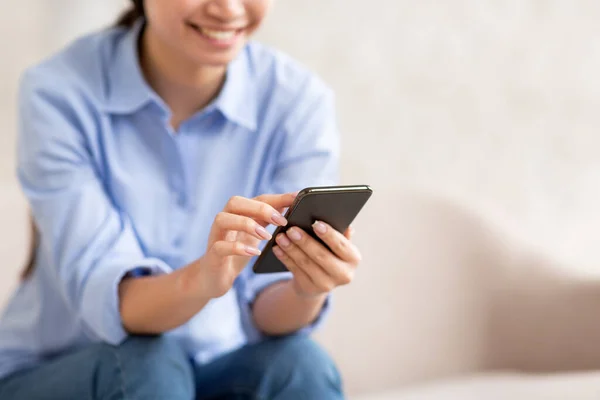 Unrecognizable lady sitting on sofa, using cell phone, cropped — 스톡 사진