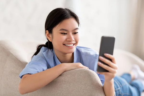 Closeup of cheerful korean woman using smartphone — 스톡 사진