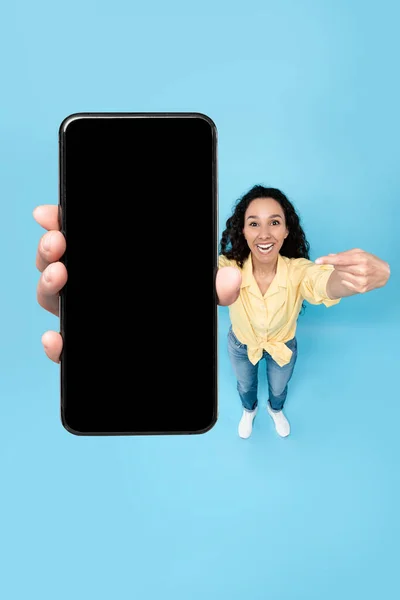 Happy lady showing blank mobile phone screen at studio — Foto Stock