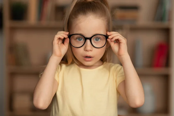 戴眼镜的小女孩，视力不好，待在家里 — 图库照片
