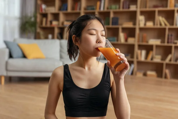 Növelje az immunrendszerét. Portré fiatal ázsiai hölgy iszik friss házi gyümölcslé, élvezi íz csukott szemmel — Stock Fotó