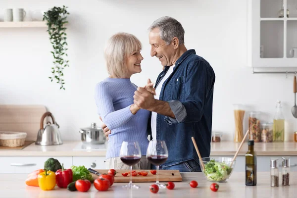 Beautiful senior couple celebrating anniversary, making dinner — Stockfoto