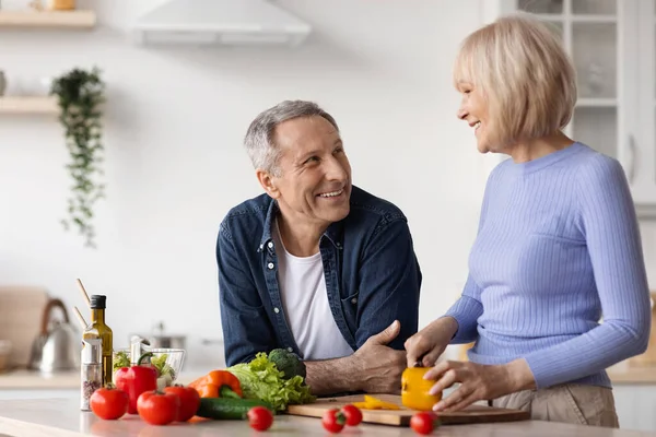 Glad senior kvinna matlagning för sin man — Stockfoto