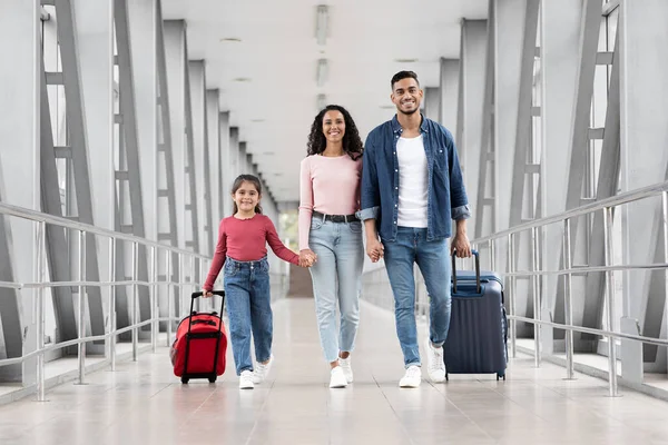 Hermosa familia árabe de tres con maletas caminando en la terminal del aeropuerto juntos — Foto de Stock