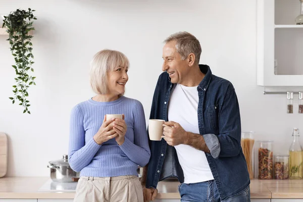 Pár důchodců pije kávu v kuchyni — Stock fotografie