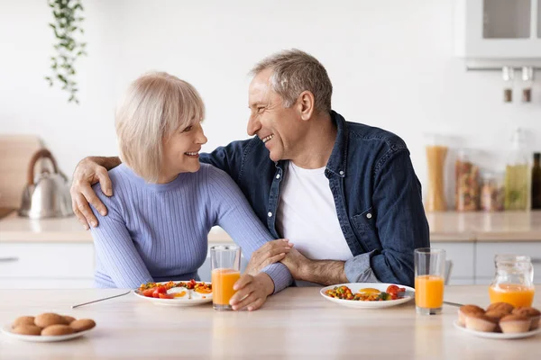 Loving senior husband and wife having breakfast together — Stockfoto