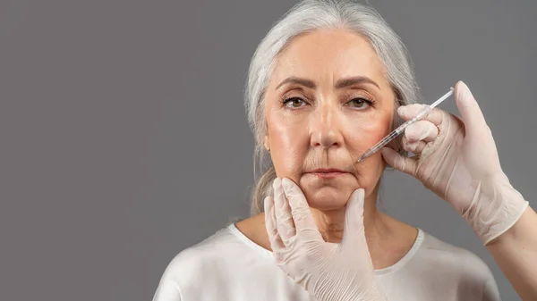 Beautiful senior woman using injection medicine to prevent aging, receiving beauty shots of collagen or hyaluronic acid — Fotografia de Stock