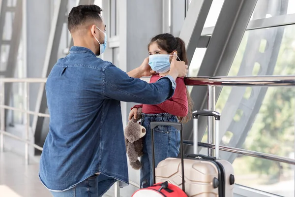 Dad Putting Mask To Little Daughter While They Standing At Airport Terminal —  Fotos de Stock