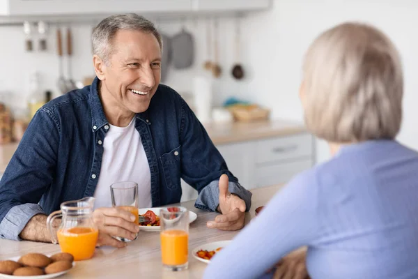 Cheerful senior man having breakfast with his wife — Stockfoto