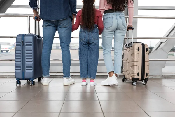 Genitori e piccola figlia in attesa in aeroporto con valigie, vista posteriore — Foto Stock