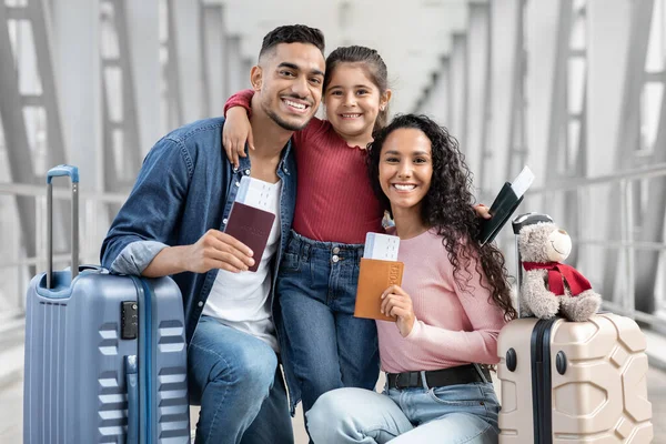 Happy arab parents and daughter relaxing in airport with baggage and tickets — Foto Stock