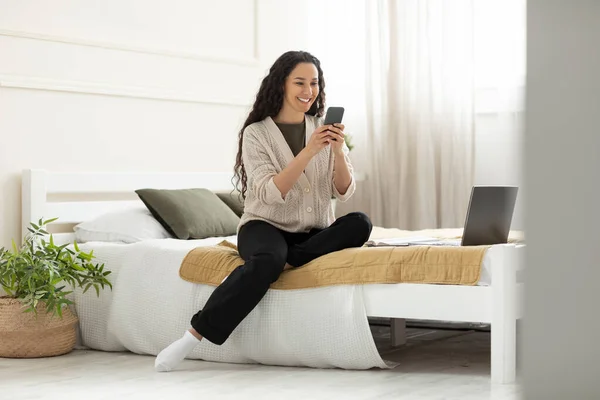 Retrato de mujer sonriente usando smartphone en casa — Foto de Stock