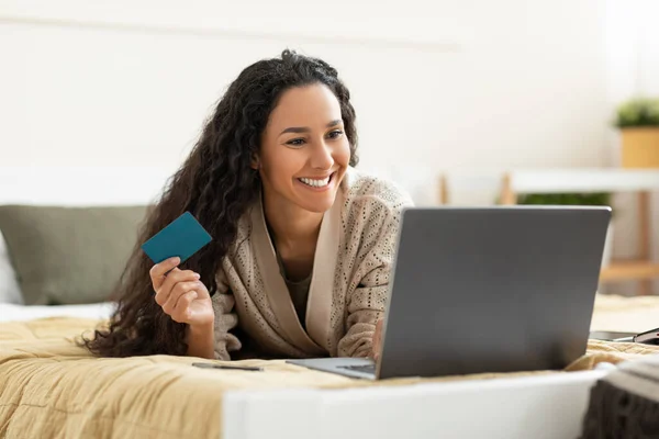 Lässig lächelnde Frau mit PC und Kreditkarte zu Hause — Stockfoto