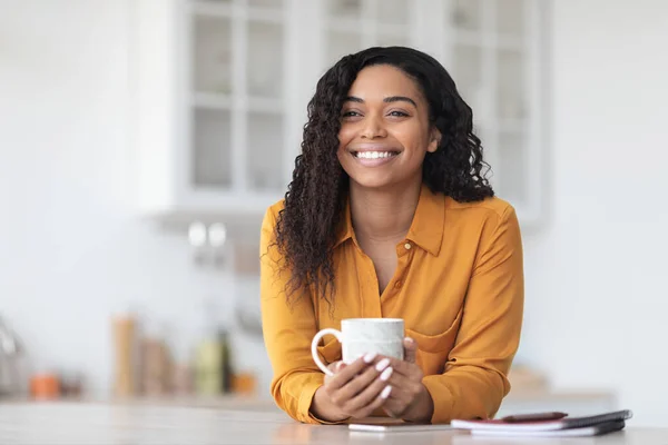 Mooie zwarte vrouw die koffiepauze heeft, kijkend naar kopieerruimte — Stockfoto