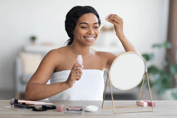 Wanita kulit hitam yang menarik menerapkan produk kecantikan setelah mandi — Stok Foto