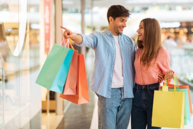 Husband Pointing Showing Shop To Wife, Couple Shopping In Mall