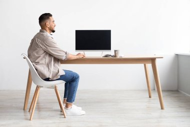 Boş monitörlü bilgisayar kullanan bir Arap.